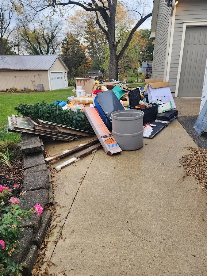Dumpster being loaded with debris for Estate Cleanout Dumpster Rental in Blue Earth